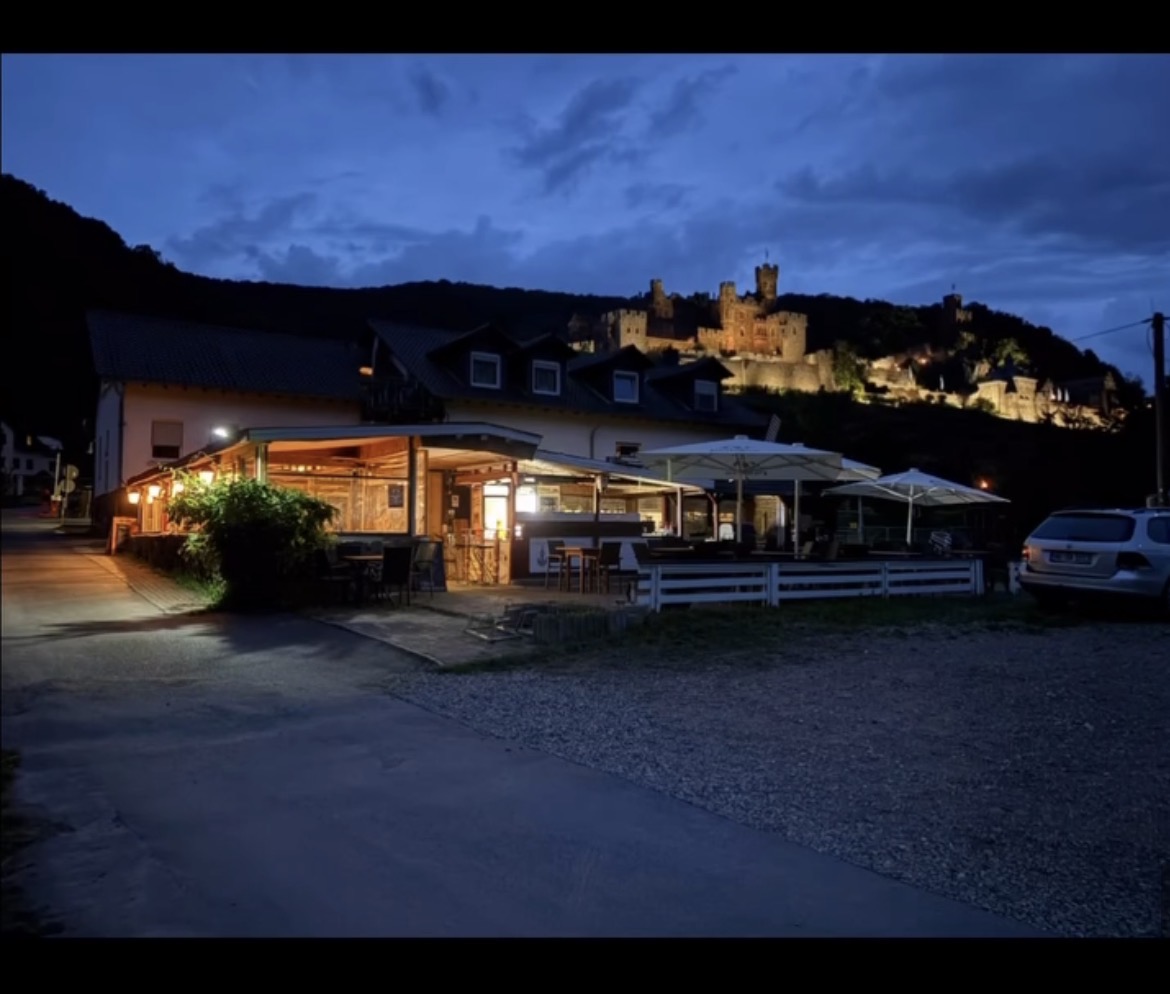 Restaurant und Terrasse am Campingplatz Marienort mit Burg Reichenstein bei Abendlicht